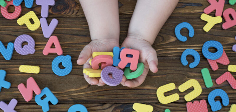 子供が英語のブロックを持っているところ
